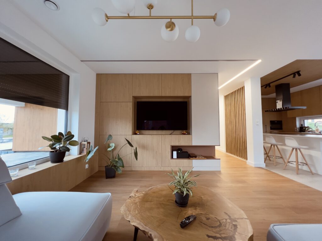 Modern living room with wooden cabinetry and open connection to the kitchen, designed by Musca Studio