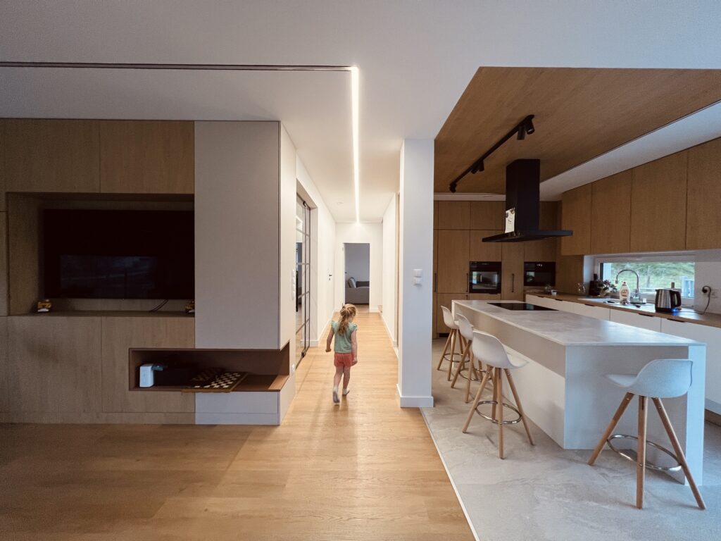 Open kitchen with central social area, connected to corridor by wooden lattice, designed by Musca Studio